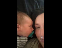 Baby with face close to mom with binky in mouth