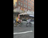 Group of people ride bicycles down street
