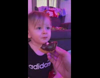 Kid adidas shirt try to eat donut