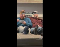 Guy touching friends hair on couch eating 