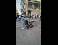 Woman in wheelchair gets up and joins street performer