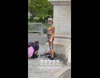 Graduate Poses for Photos Near Old Man Being Painted On