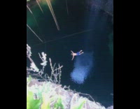 shirtless man back flip underground cave