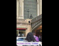 Man in black spiderman costume edge of building