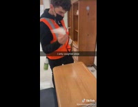 Orange vest guy comes into class and cleans desk 