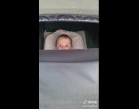 Baby in a carriage with big eyes stare at the camera