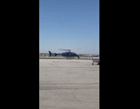 Helicopter flies with slow rotor blades at the airport