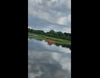 Shirtless older guy sits red kayak selfie 