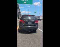 Man riding motorcycle shows funny car sticker