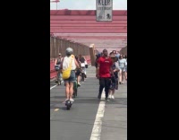 Man rides bike while holding big box