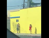 Woman red dress dance beside yellow wall