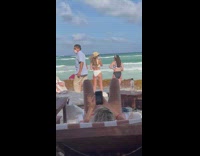 Woman lie down takes picture of three bikini women