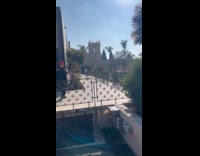 Man red hat tiktok dance beside building