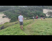 Sea foam fly towards people on hill