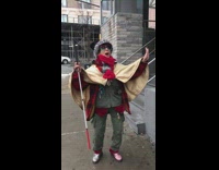 Woman with walking cane sings and stomps her feet on sidewalk