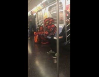 Red pixel monster costume cosplay on subway train