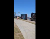 Woman vlogs behind the large beach artwork