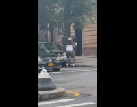 Guy lifts trashcan near sidewalk for workout 