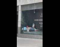 Guy lays in outdoor nook of building