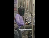 Purple shirt black costume mask guy reads
