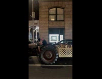 Man rides tractor with goats on back
