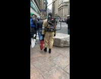 Guy in Ghostbuster costume crosses the street with theme song playing