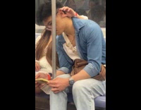 Woman playing with her boyfriends ear on subway