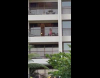 Girl wearing pink dress dances outside balcony