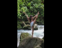 Lady Does Yoga Pose on River Rock 