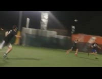 Soccer play in green jersey goes in for a goal and gets blocked by girl goalie