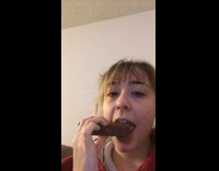 Girl eating wafer cookie as friend talks 