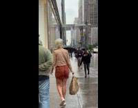 Woman walking use plastic bag as umbrella 