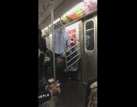 Guy hangs shirt on train hand rail