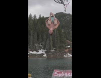 Guy rides bicycle wood ramp backflips water 