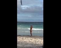 Woman dances drone above at beach