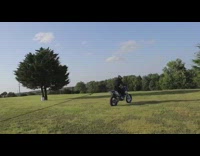 Guy dirt bike pulls friend chair grass