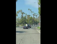 Man white suit convertible car music video shoot