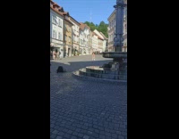 Man lie down and lifts woman with feet on the street