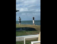 Collab IITW - Woman in white dress raise hands poses near the cliff by the beach