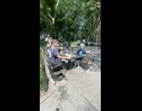 Alien sit and play chess at park