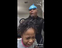 Guy blue balloon head and sunglasses dances with little girl, spits and pours water on her head