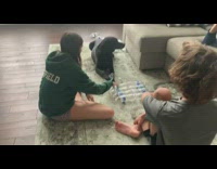 Black dog takes cap off water bottle 