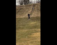 Blue jacket guy rides bicycle down hill