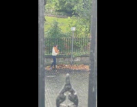 Woman yellow scarf adjusts tripod and pose