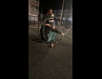 Woman spins around man at playground night