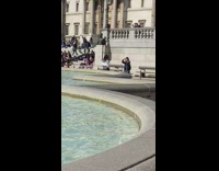 Woman in white top and leather skirt tiktok by the fountain