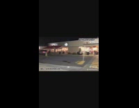 Guy yellow hair green vest diapers takes off pants and directs traffic in front of dunkin donuts