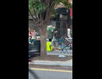 Man yellow vest balance trash can on head