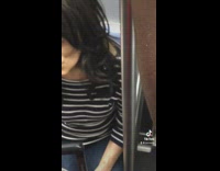 Woman on subway looking around holding cup of coffee 
