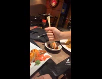 Guy uses entire hand to hold chopsticks 